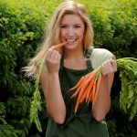 femeie care mananca morcovi ce contin vitamina A antioxidanta