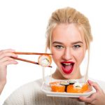 femeie care mananca peste somon ce contine selenium vitamine antioxidante