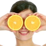 femeie care mananca portocale ce contin vitamine antioxidante