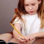 fetiță care scrie în jurnal și controlează anxietatea la copii