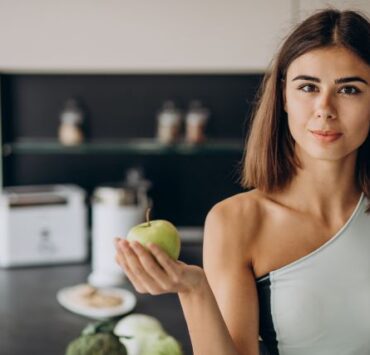 Cum ne influențează starea fizică sufletul? 8 sporty woman with apple kitchen 1
