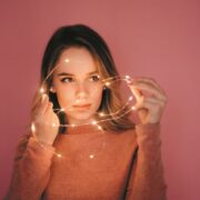 woman playing with garland pink background